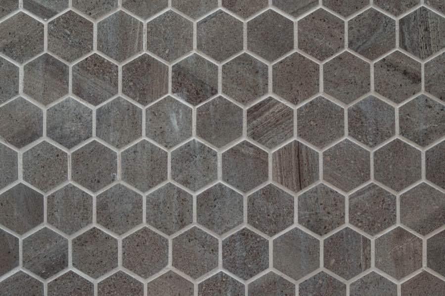Mosaik aus grauen Sechseckfliesen mit gleichmäßig heller Fuge